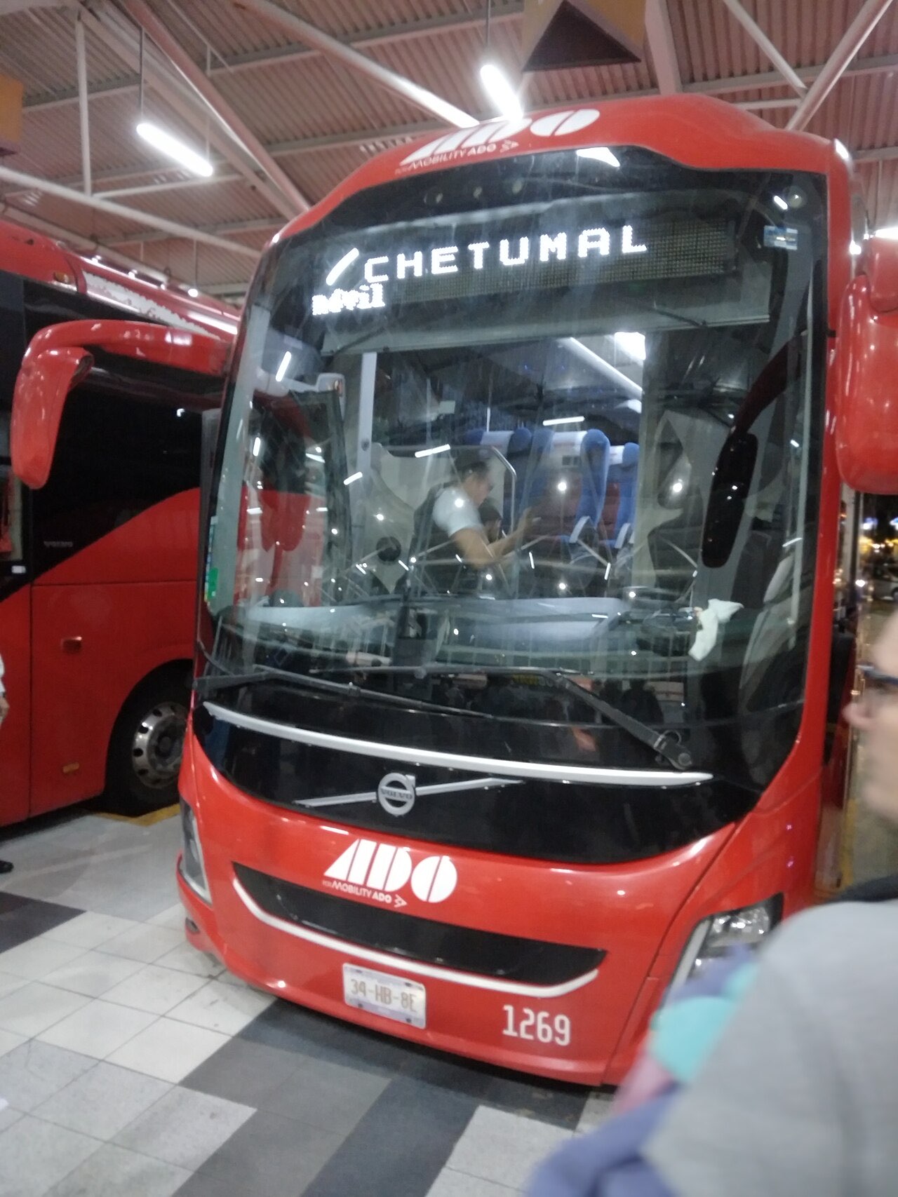 A red ADO coach with a Chetumal destination sign parked in a bus terminal